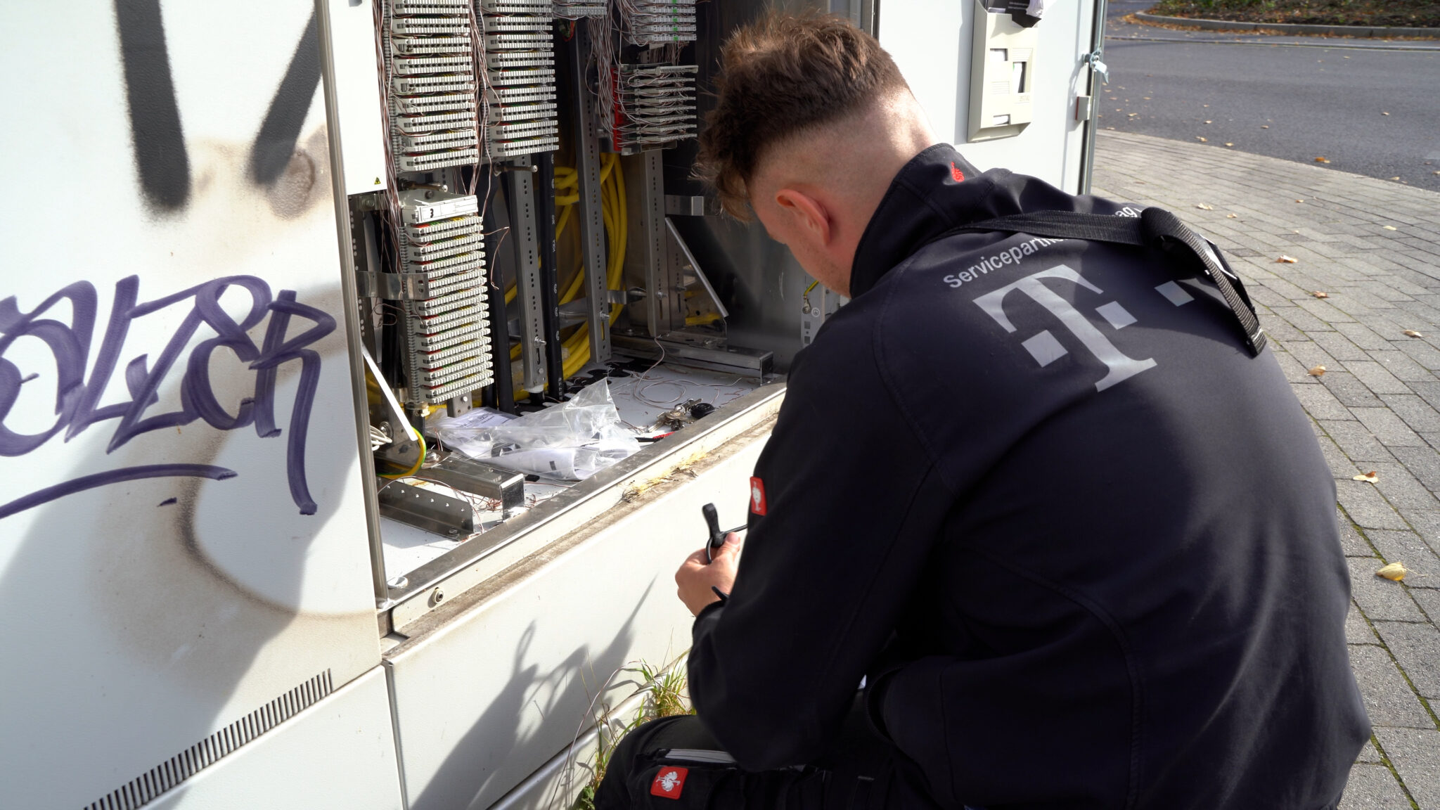 Techniker arbeitet am geöffneten Kabelverzweiger